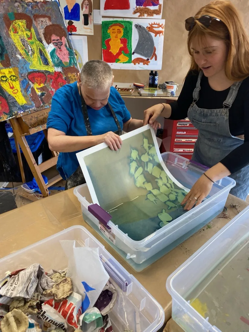Cheri and a facilitator working together on a screen-printing project at the Progressive Art Studio, 2026