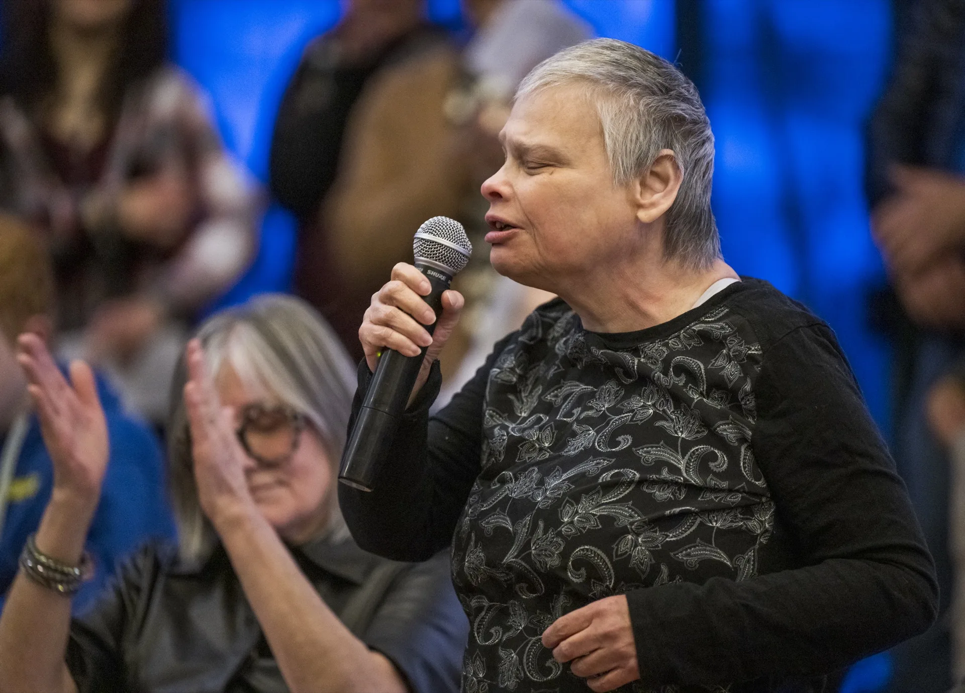 Cheri signing in front of a crowd at the art center during the Suitcase Stories exhibit, 2022